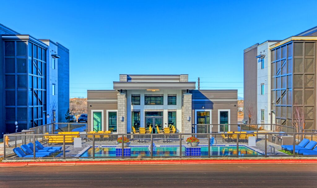 Pool with deck seating and adjacent clubhouse